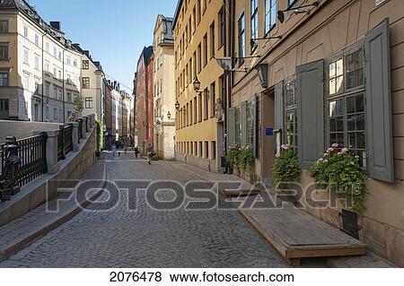 Stock Photo - Buildings And Pedestrians Walking Along A Narrow Street In Gamla Stan Old Town; Stockholm Sweden. Fotosearch