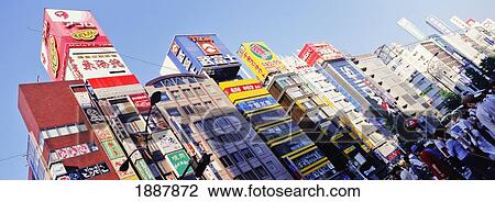 Stock Image - Buildings Covered In Advertising Signs In Shinjuku. Fotosearch