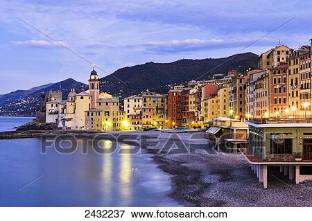 Stock Photo - Buildings illuminated by lights along the water's edge at sunrise; Camogli, Liguria, Italy. Fotosearch