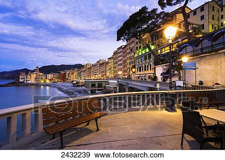 Stock Photo - Buildings illuminated by lights along the water's edge at sunrise; Camogli, Liguria, Italy. Fotosearch