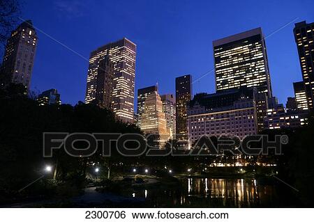 Stock Photograph - Buildings in Midtown Manhattan, viewed from South Central Park at dusk; New York City, New York, United States of America. Fotosearch