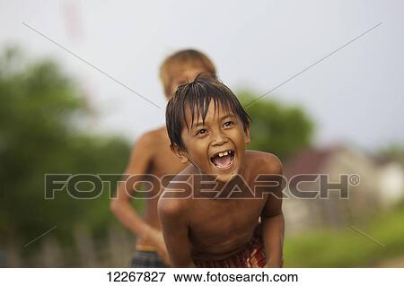 Stock Photo - Bunong boys playing volleyball; Mondulkiri, Cambodia. Fotosearch