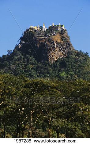 Stock Photography - Burma (Myanmar), Bagan, Mount Popo, Temples On Mountain Top, Trees In Foreground.. Fotosearch