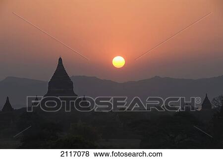Stock Photo - Burma (Myanmar), Bagan, Silhouetted temples and sunball at sunset.. Fotosearch
