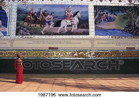 Stock Photograph - Burma (Myanmar), Bago, Shwethalyaung, Novice Observing Painted Reliefs On Wall.. Fotosearch