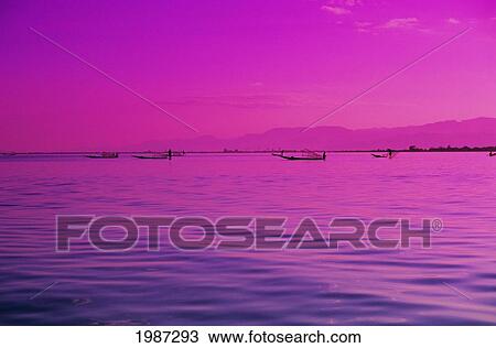 Burma (Myanmar), Inle Lake, Pink And Purple Sunset, Reflections On Rippled Water, Fishermen In Distance. View Large Photo Image Stock Image - Burma (Myanmar), Inle Lake, Pink And Purple Sunset, Reflections On Rippled Water, Fishermen In Distance.. Fotosearch