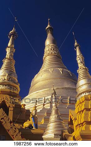 Burma (Myanmar), Yangon, Shwedagon Paya, Close-Up Of Three Golden Steeples In Sunlight. View Large Photo Image Stock Photograph - Burma (Myanmar), Yangon, Shwedagon Paya, Close-Up Of Three Golden Steeples In Sunlight.. Fotosearch