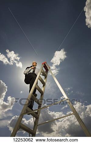Businessman on a ladder with blue sky and cloud; Edmonton, Alberta, Canada View Large Photo Image Stock Image - Businessman on a ladder with blue sky and cloud; Edmonton, Alberta, Canada. Fotosearch