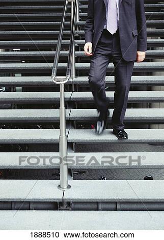 Stock Image - Businessman Walking Down Steps, London. Fotosearch