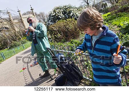 Stock Photo - Busker at the Brighton Pavillion and young boy; Brighton, England. Fotosearch