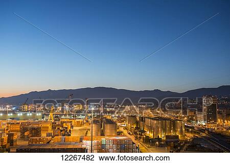 Stock Image - Busy port illuminated at dusk; Genoa, Liguria, Italy. Fotosearch