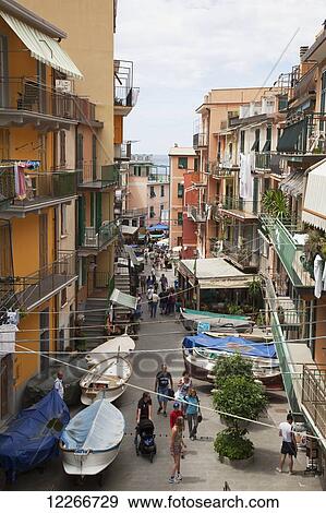 Stock Photo - Busy streets of Manarola with people and boats; Manarola, Liguria, Italy. Fotosearch