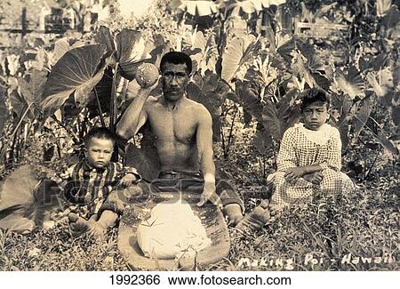 Stock Photograph - C. 1910 Black And White Photograph, Hawaiian Man Pounding Poi Surrounded By Family. Fotosearch