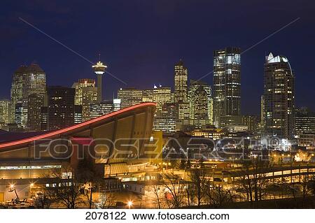 Stock Image - Calgary Skyline With Saddledome At Dusk With City Lights; Calgary Alberta Canada. Fotosearch