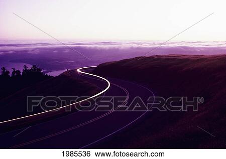 California, Big Sur Coast, Light Streak From Car On Winding Road At Dusk. View Large Photo Image Stock Photograph - California, Big Sur Coast, Light Streak From Car On Winding Road At Dusk.. Fotosearch
