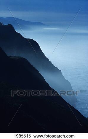 Stock Photography - California, Big Sur Coast, Silhouetted Cliffs Along Foggy Ocean Shoreline.. Fotosearch