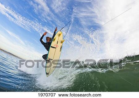 Stock Photo - California, Huntington Beach, Surfer Catches Air On A Fun Playful Wave. For Editorial Use Only.. Fotosearch