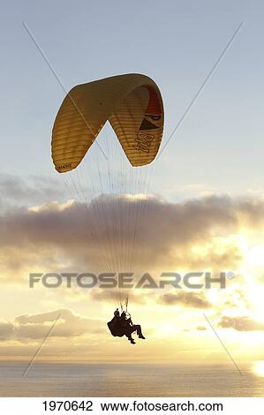 Stock Image - California, La Jolla, Paraglider Flying Near Clouds. For Editorial Use Only.. Fotosearch