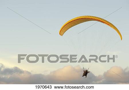 Stock Image - California, La Jolla, Paraglider Flying Near Clouds. For Editorial Use Only.. Fotosearch