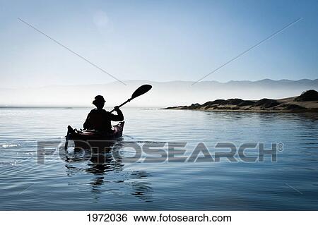 Stock Photograph - California, Morro Bay State Park, Woman Kayaking In Ocean, Silhouette.. Fotosearch