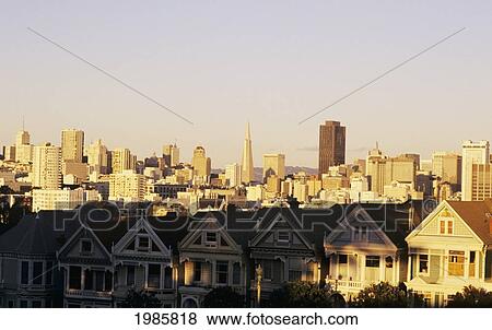 Stock Photo - California, San Francisco, Row Of Unique Homes, City Skyline In Background.. Fotosearch