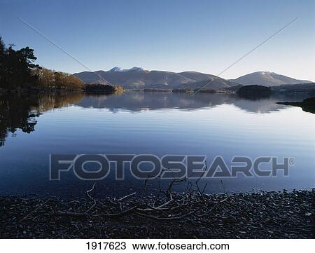 Stock Image - Calm Waters Of Derwent Water Shortly After Dawn. Fotosearch