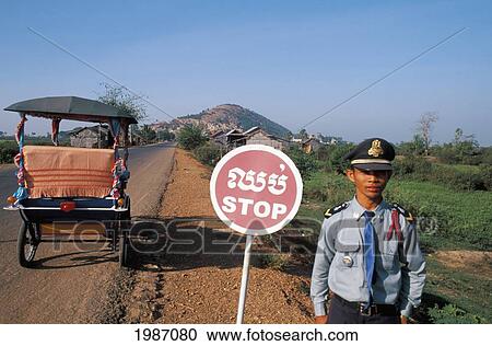 Cambodia, Lake Tonle Sap Village, Policeman Standing Beside Road With Stop Sign. View Large Photo Image Stock Image - Cambodia, Lake Tonle Sap Village, Policeman Standing Beside Road With Stop Sign.. Fotosearch
