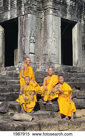 Stock Photography - Cambodia, Siem Reap, Agnkor Thom, Bayon Temple With Four Monks Sitting On Stairs. Fotosearch