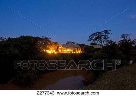 Stock Image - Camp fire beside mess tent at dusk, Ol Pejeta Bush Camp, Ol Pejeta Conservancy; Kenya. Fotosearch