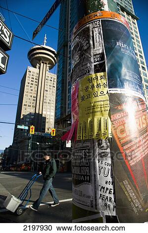 Stock Image - Canada, British Columbia, Harbor Centre building and posters on lamppost; Vancouver. Fotosearch