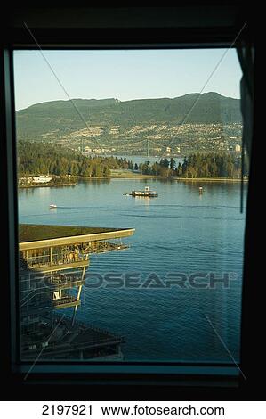 Stock Image - Canada, British Columbia, mountains and boats; Vancouver, Harbor, View out of Pan Pacific Hotel window of Vancouver Waterfront. Fotosearch
