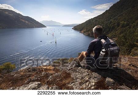 Canada, British Columbia, Vancouver Island, Sansum Narrows, Man watching sailing regatta from Maple Mountain View Large Photo Image Stock Photography - Canada, British Columbia, Vancouver Island, Sansum Narrows, Man watching sailing regatta from Maple Mountain. Fotosearch