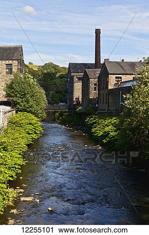 Stock Image - Canal flowing past houses; Yorkshire, England. Fotosearch