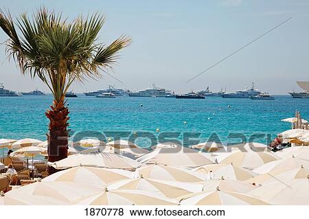 Cannes, Provence, France; Beach Umbrellas On The Shore And Boats In The Water View Large Photo Image Stock Photo - Cannes, Provence, France; Beach Umbrellas On The Shore And Boats In The Water. Fotosearch