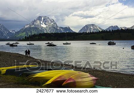 Canoes and kayaks on the beach, two women walk as they wait out the impending storm; Wyoming, United States of America View Large Photo Image Stock Photo - Canoes and kayaks on the beach, two women walk as they wait out the impending storm; Wyoming, United States of America. Fotosearch