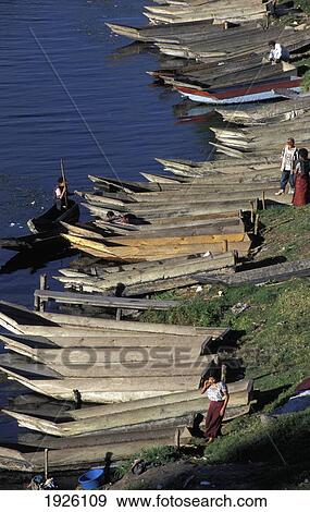 Stock Photo - Canoes Lined Up Along The Shore, Santiago. Fotosearch