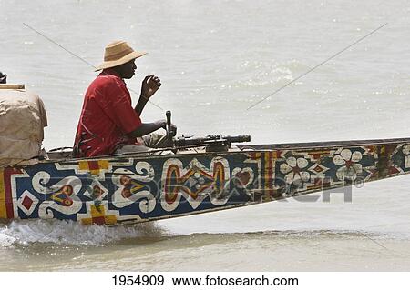 Captain of a Pinasse carrying cargo and passengers on the Niger River between Mopti and Lake Debo, Mali View Large Photo Image Stock Photo - Captain of a Pinasse carrying cargo and passengers on the Niger River between Mopti and Lake Debo, Mali. Fotosearch
