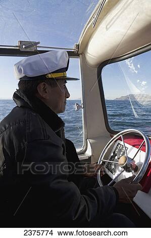 Captain of the Glasnost Arrow piloting the waters of Lake Titicaca, Huatajata, La Paz Department, Bolivia View Large Photo Image Picture - Captain of the Glasnost Arrow piloting the waters of Lake Titicaca, Huatajata, La Paz Department, Bolivia. Fotosearch