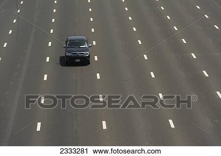 Stock Image - Car Driving Along Wide Section Of Sheikh Zayed Road; Dubai, United Arab Emirates. Fotosearch