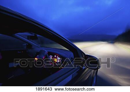 Stock Image - Car On Road At Dusk. Fotosearch