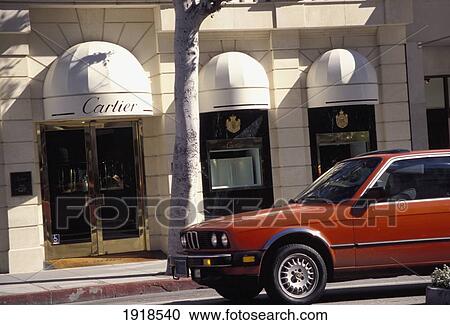 Stock Image - Car Passing Shops On Rodeo Drive; Los Angeles, California, Usa. Fotosearch