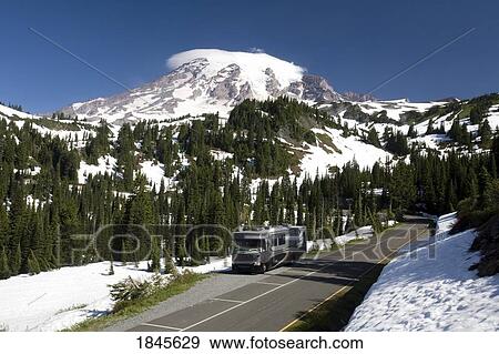 Stock Photo - Caravan On Empty Road, Mt. Rainier In Background; Mt Rainier National Park, Washington State, Usa. Fotosearch