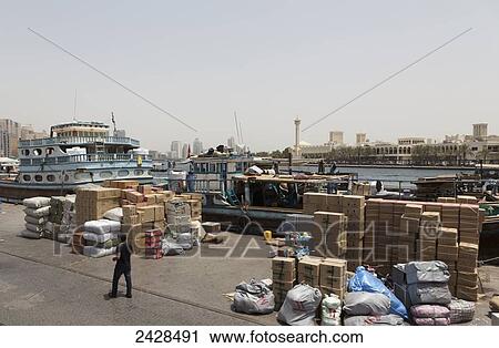 Stock Image - Cargo piled up on the waterfront; Dubai, United Arab Emirates. Fotosearch
