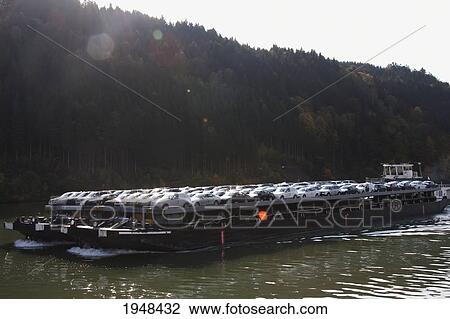 Stock Image - Cargo ship carrying cars on the Danube River in Upper Austria, Upper Austria, Austria. Fotosearch