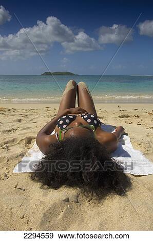 Caribbean, Grenada, Grenadines, Pretty black woman wearing swimsuit sunbathing on Paradise Beach; Carriacou Island View Large Photo Image Stock Photo - Caribbean, Grenada, Grenadines, Pretty black woman wearing swimsuit sunbathing on Paradise Beach; Carriacou Island. Fotosearch