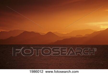 Caribbean, Orange Sunset Over Seascape, Hazy Mountains In Background. View Large Photo Image Stock Image - Caribbean, Orange Sunset Over Seascape, Hazy Mountains In Background.. Fotosearch