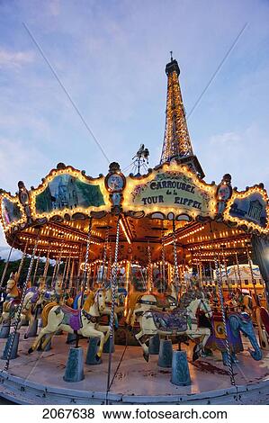 Stock Photo - Carousel By The Eiffel Tower In The Evening, Paris, France. Fotosearch