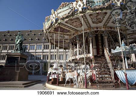 Carousel In The Town Square With A Bronze Statue And Blue Sky; Strasbourg, France View Large Photo Image Stock Image - Carousel In The Town Square With A Bronze Statue And Blue Sky; Strasbourg, France. Fotosearch