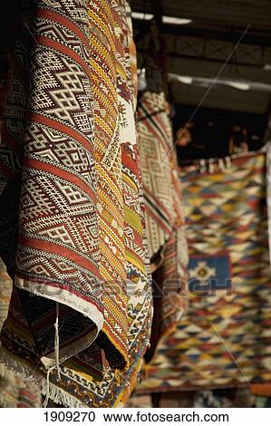 Stock Image - Carpets And Rugs Hanging Up In Stall In Souk, Marrakesh, Morocco. Fotosearch