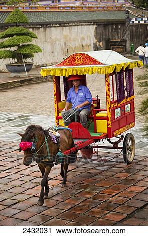 Stock Image - Cart driver at the Gate of the Imperial Citadel; Hue, Vietnam. Fotosearch